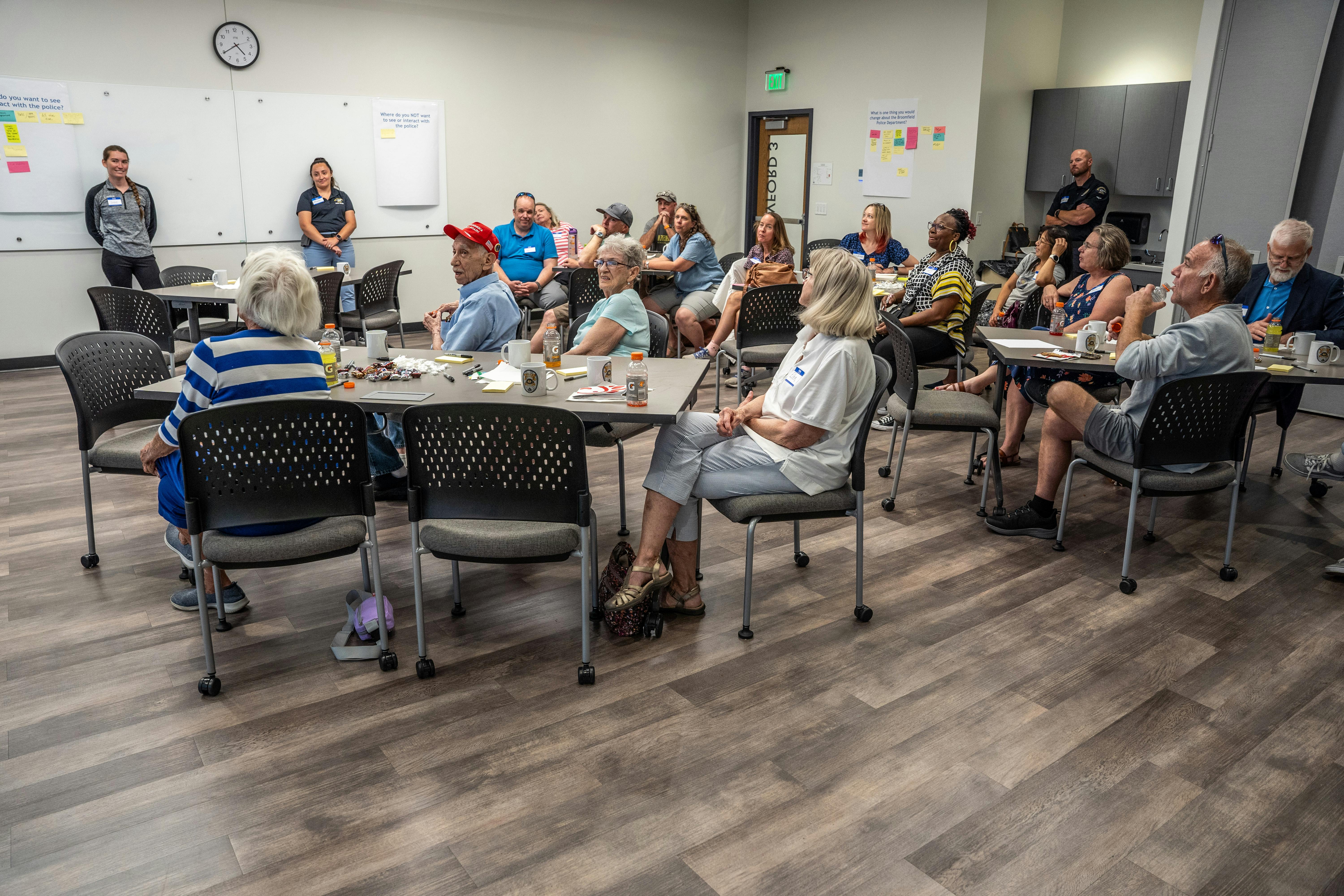 Room full of participants look onwards as a facilitator welcomes them to the session
