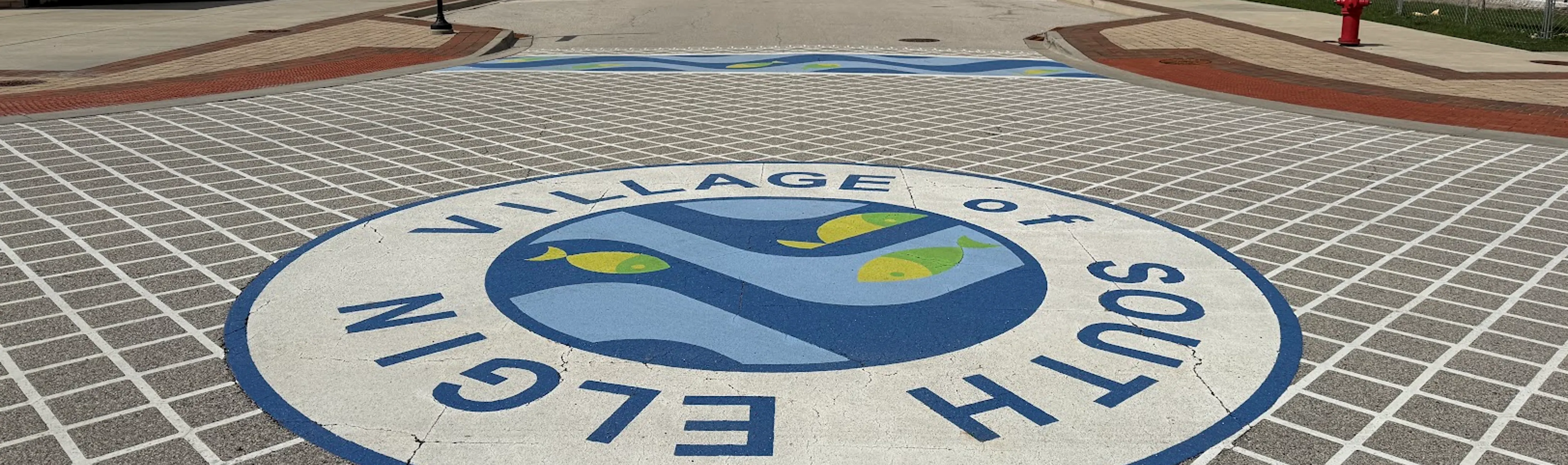 Street scene in South Elgin with the Village of South Elgin seal in the middle of an intersection. 