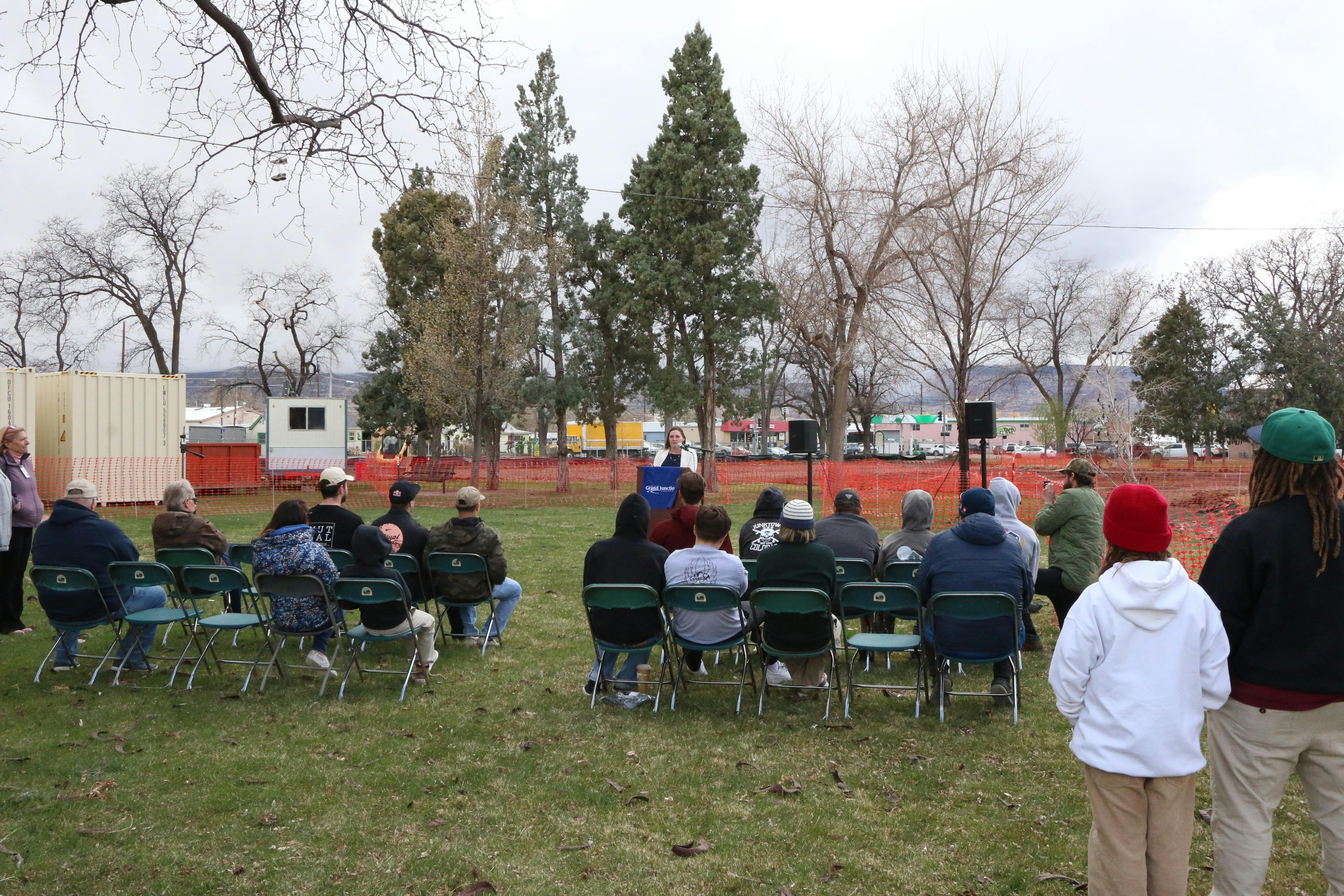 Photo of a crowd with a person standing at a podium in the background