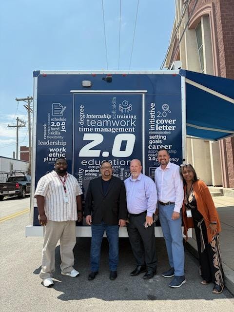 HACP staff pose with community partners outside the W.O.W. CyberBus 2.0