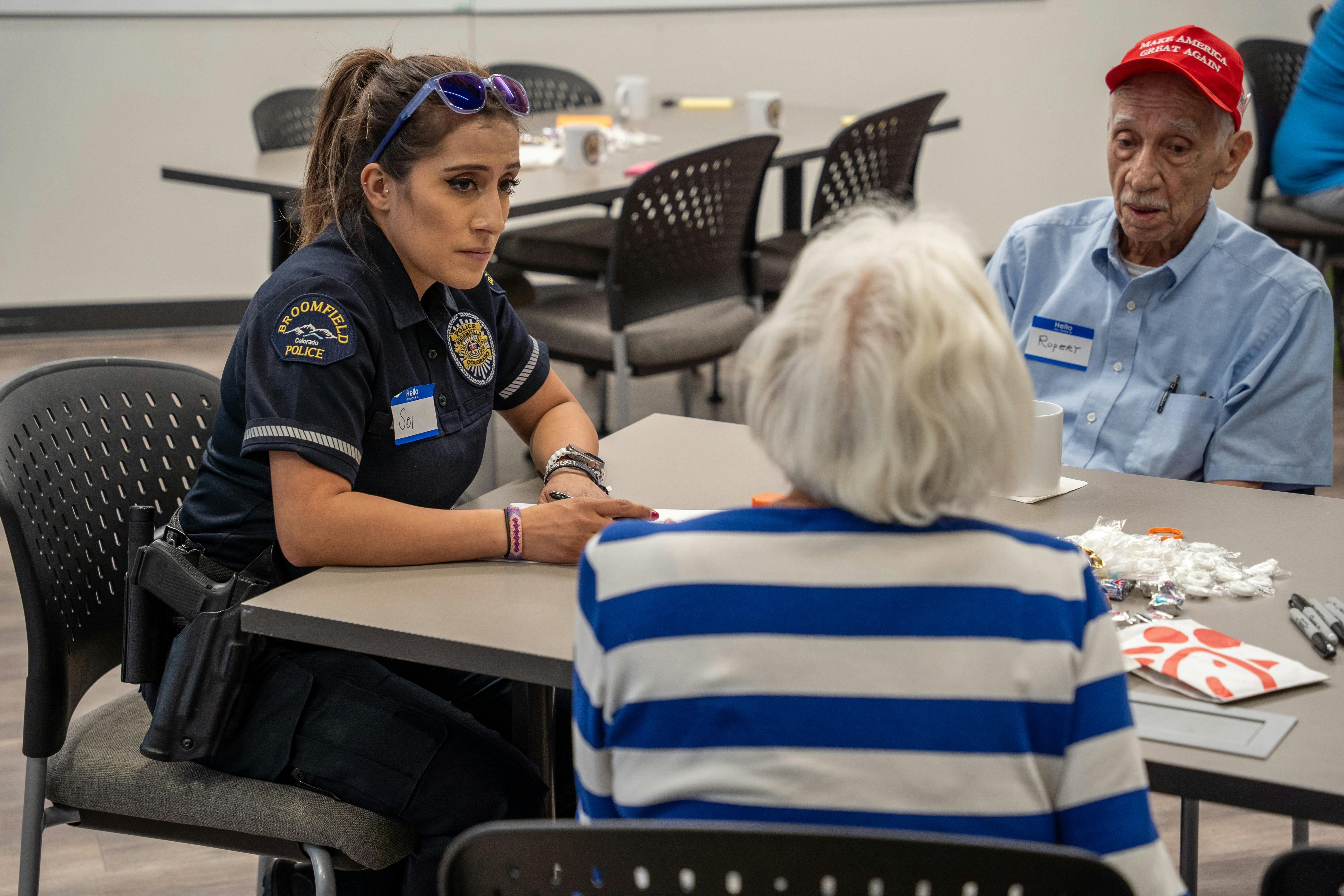 Police officer looks intently at a woman speaking in a small group