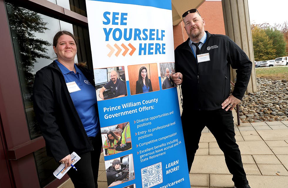 Staff with promotional banner at the Fall 2025 Career Expo