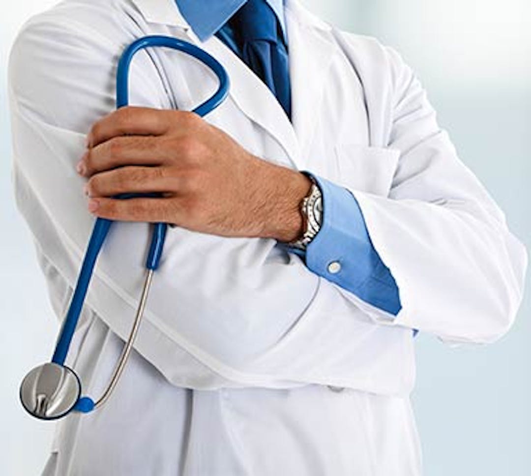 Doctor holding his stethoscope in his left hand with arms folded looking off to the right.