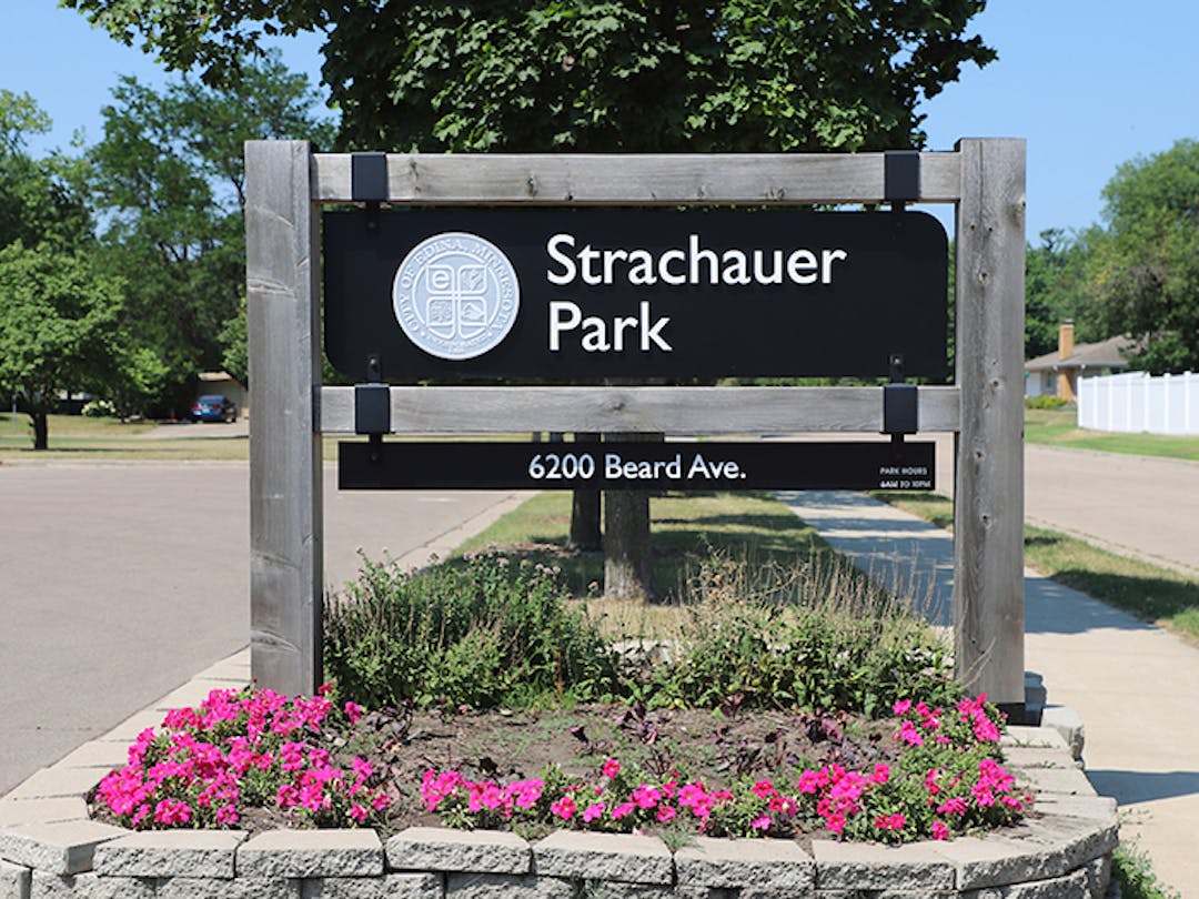 Strachauer Park sign with shelter building and basketball court in background