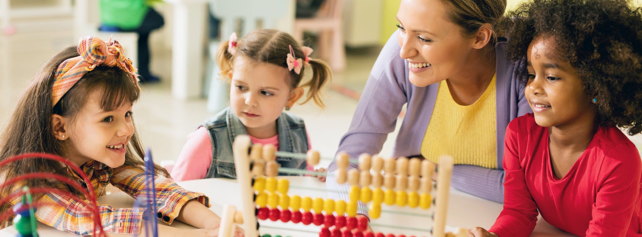 Teacher and Students Smiling at a Preschool