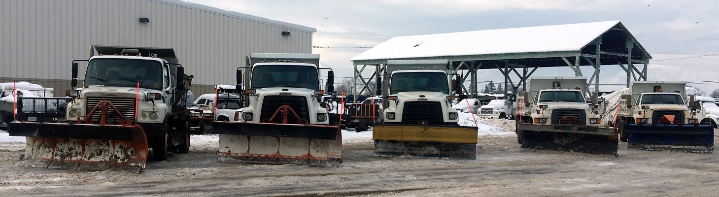 A row of parked snowplows