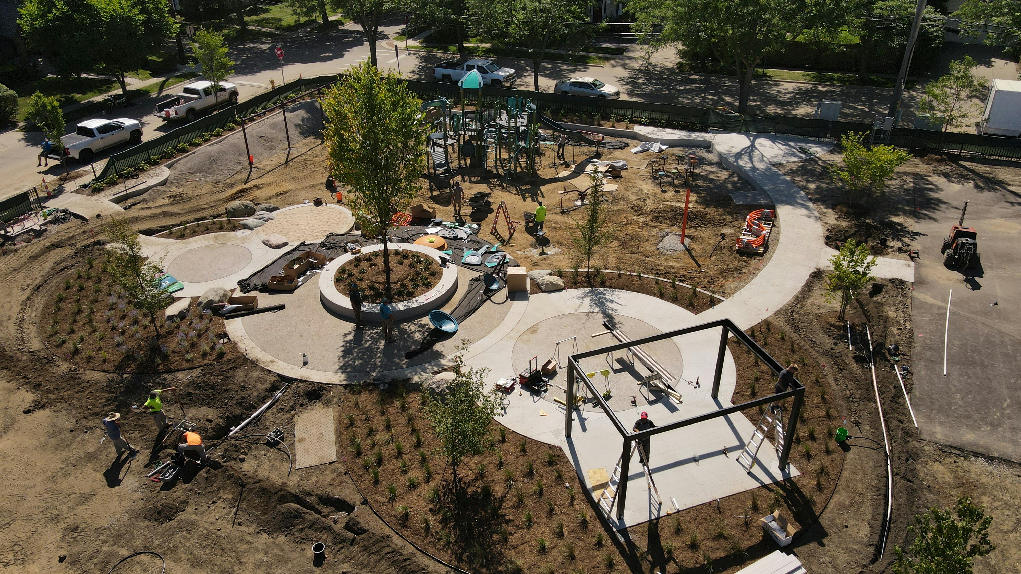 Close up of gathering area and playground.  The frame of the pergola is up.