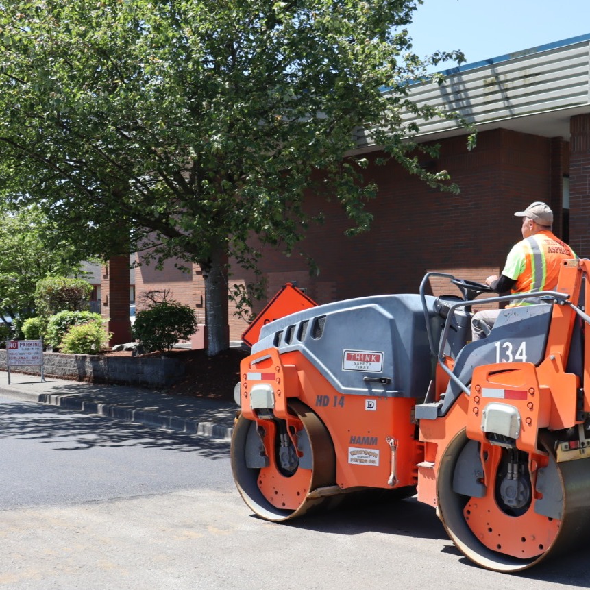 Contractor rolling fresh asphalt