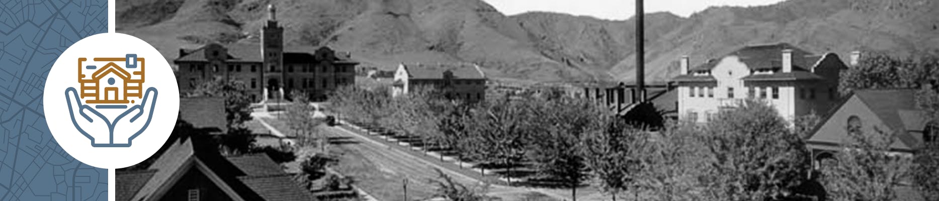 Historic photo of a street in Golden with trees in the median and mountains in the background.