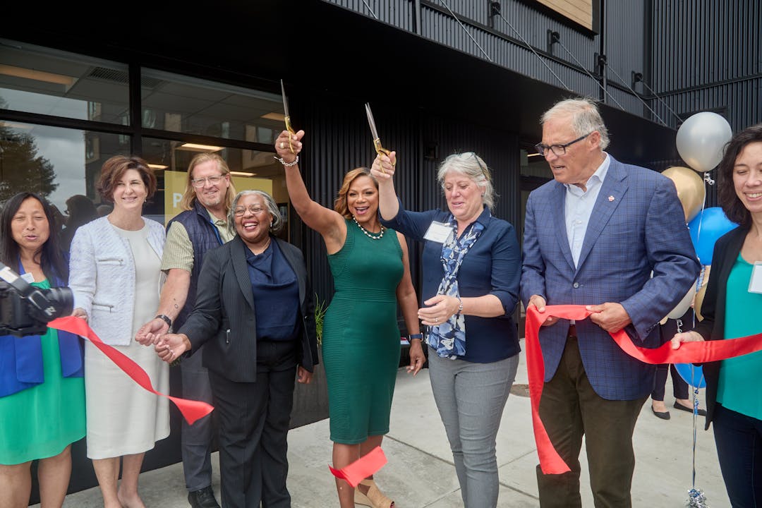 City council members, county councilmember, and governor cutting the ribbon for new permanent supportive housing.