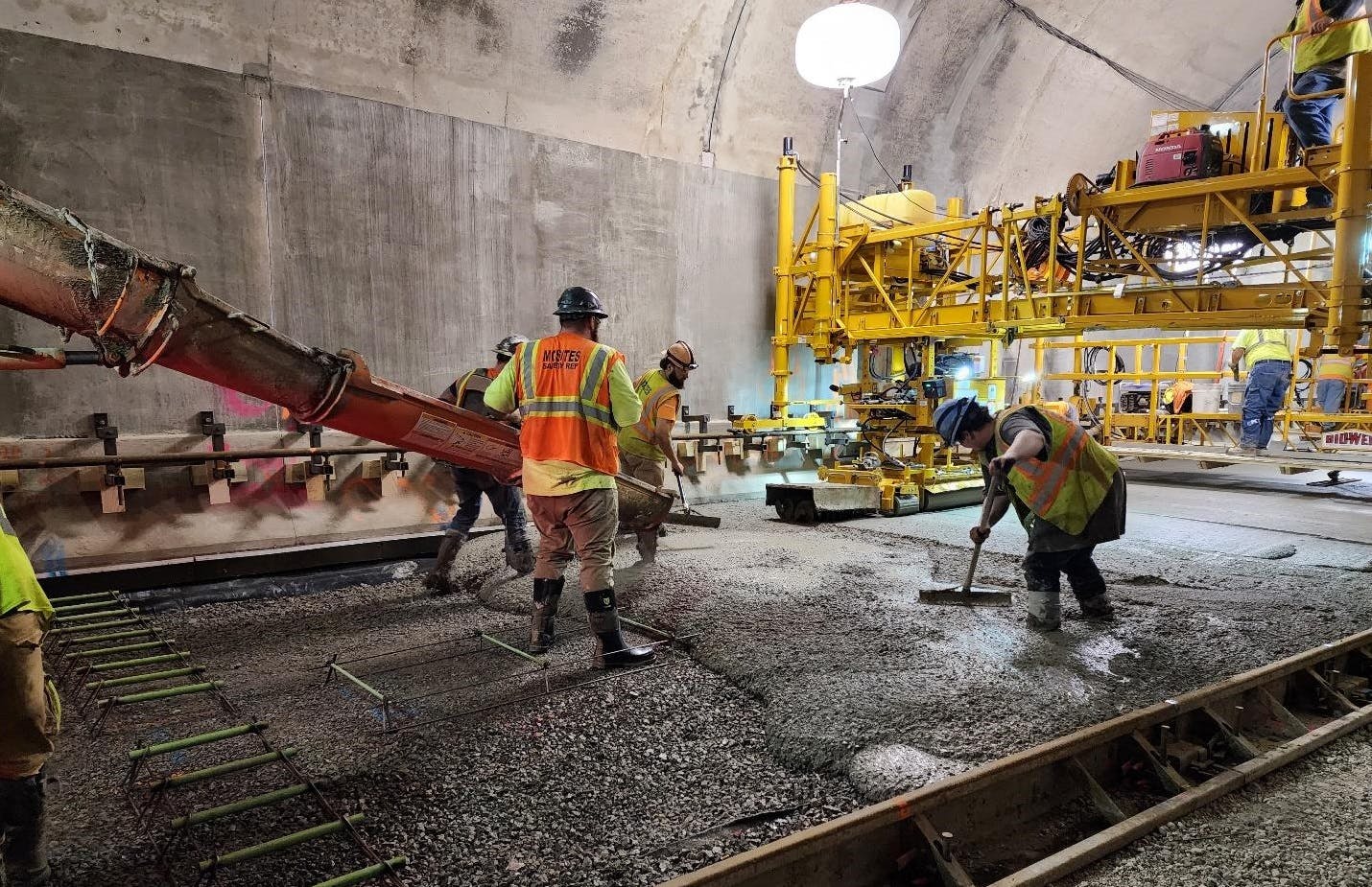 Crews pour a new concrete roadway in the inbound Armstrong Tunnel