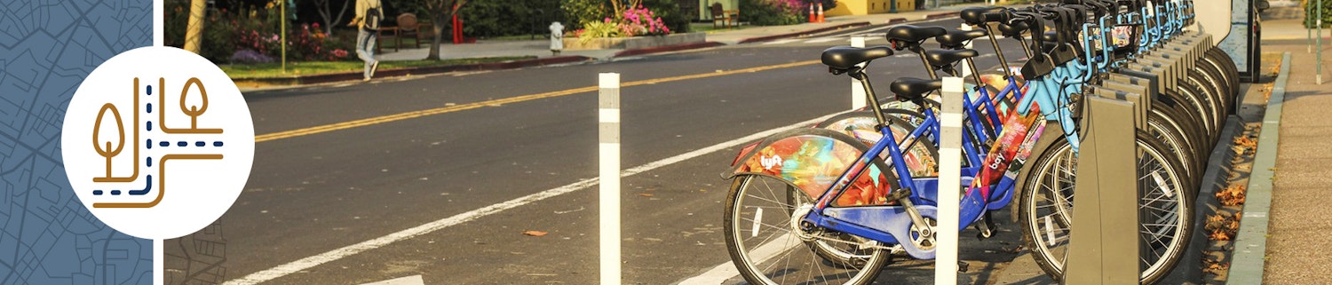 E-bikes are lined up and docked on a street.