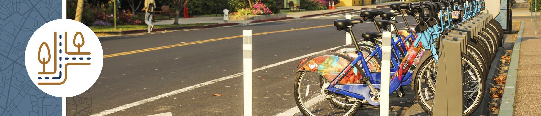E-bikes are lined up and docked on a street.