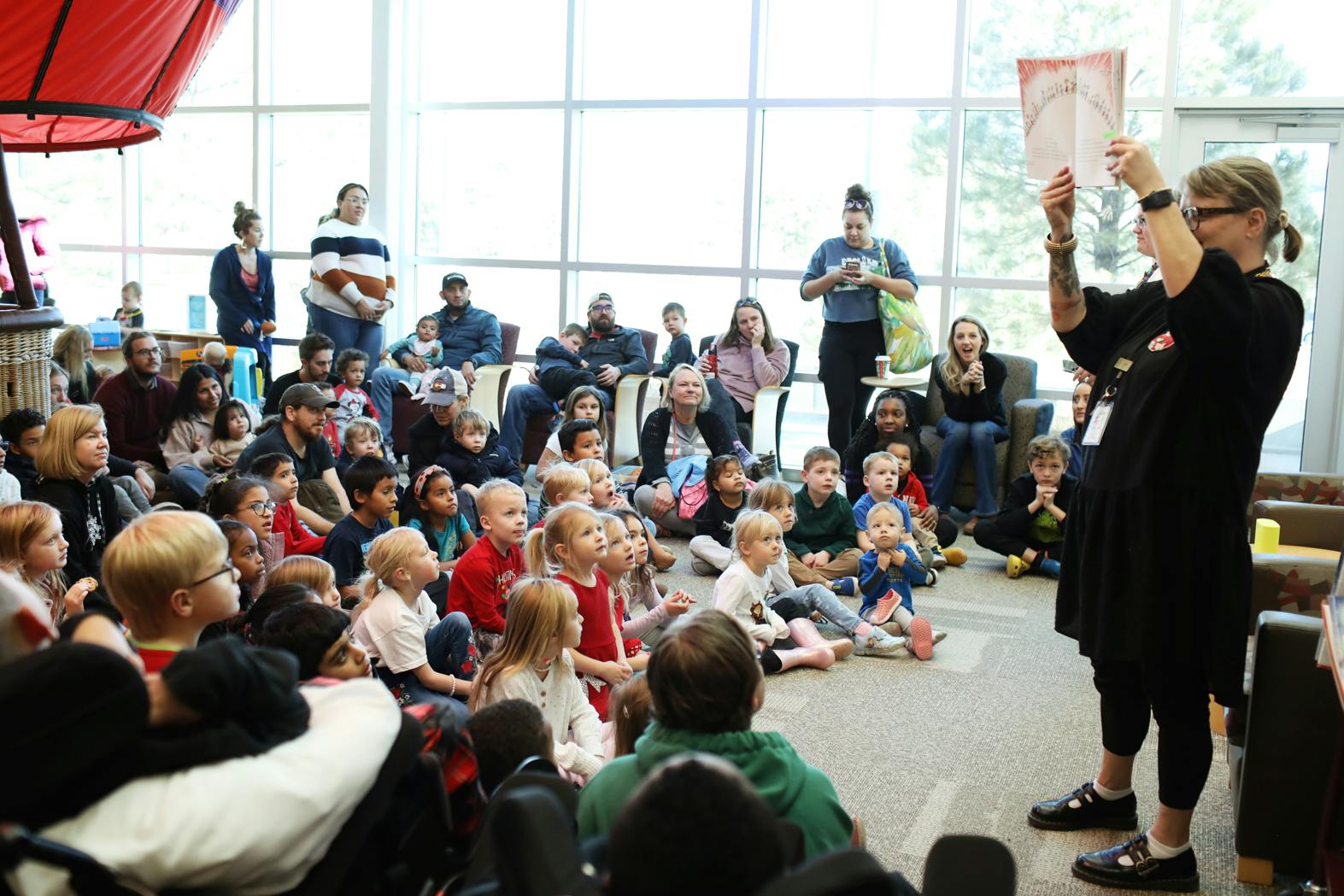 Library staff reading a book to a group of children