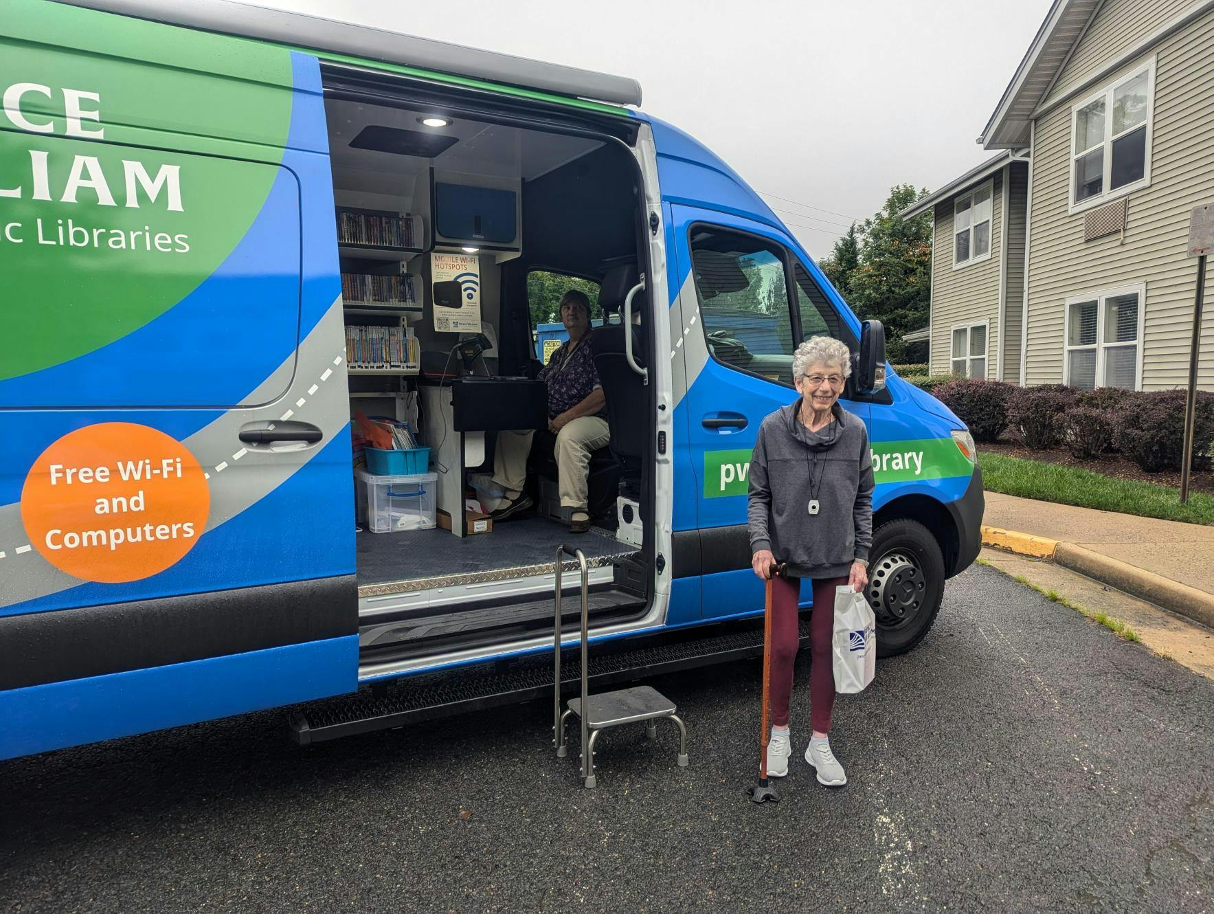 Senior person standing outside Prince William Public Libraries mobile library van