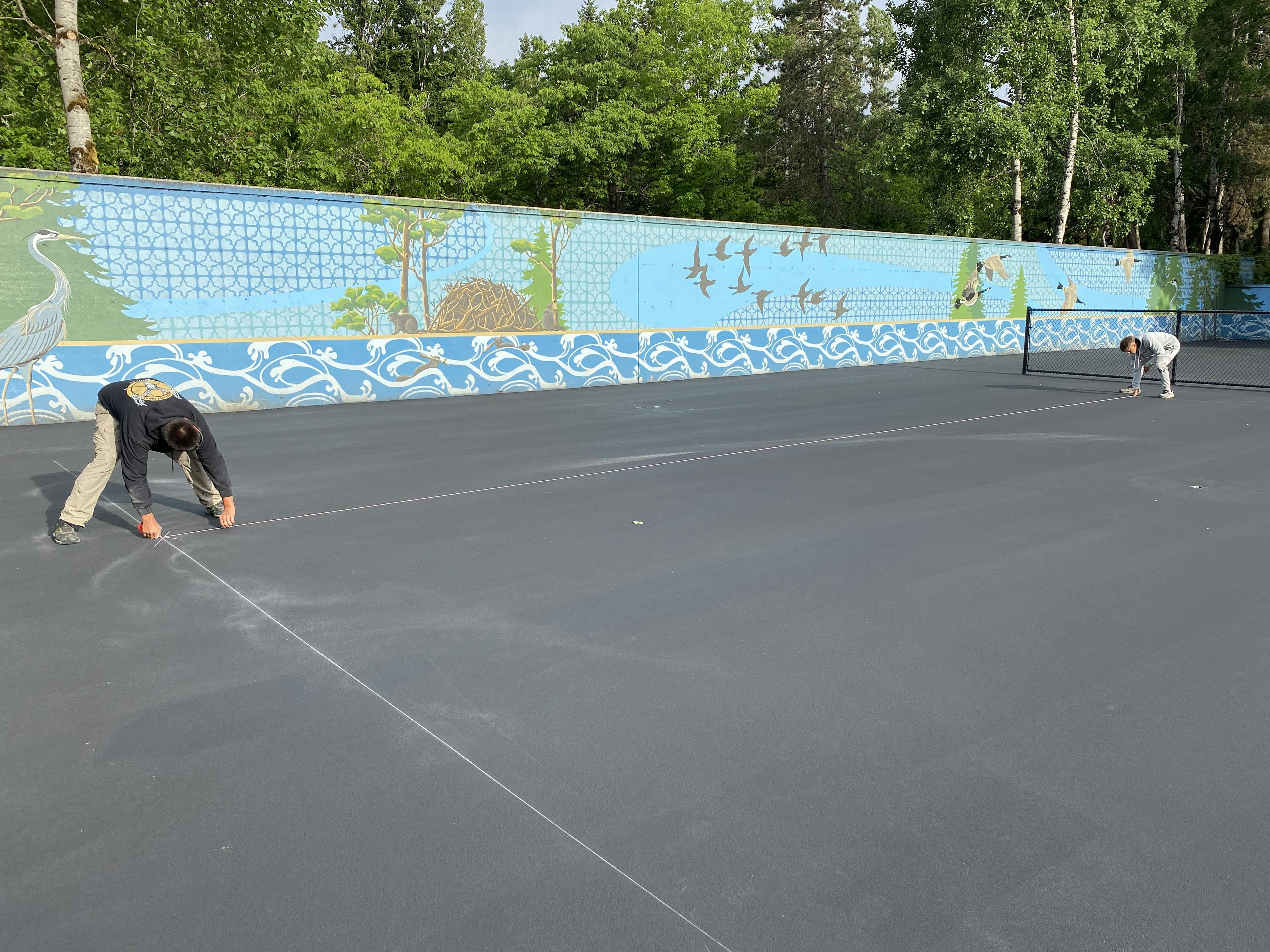 Prepping the courts for permanent surfacing and striping