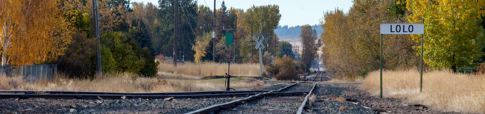 Lolo sign near train tracks on fall day